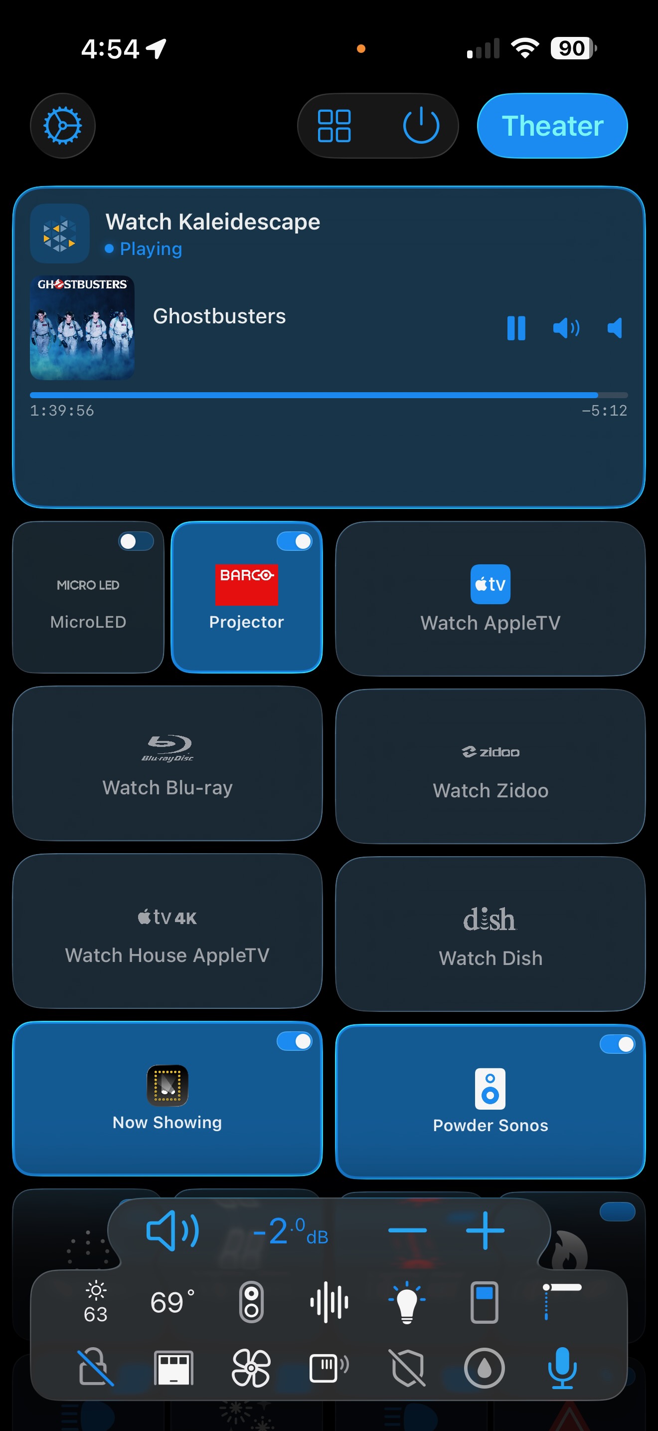 A Roomie Remote Theater room: MicroLED and Barco projector selection, Kaleidescape playing mid-movie, Now Showing, Sonos, plus lighting and climate controls — all on one screen